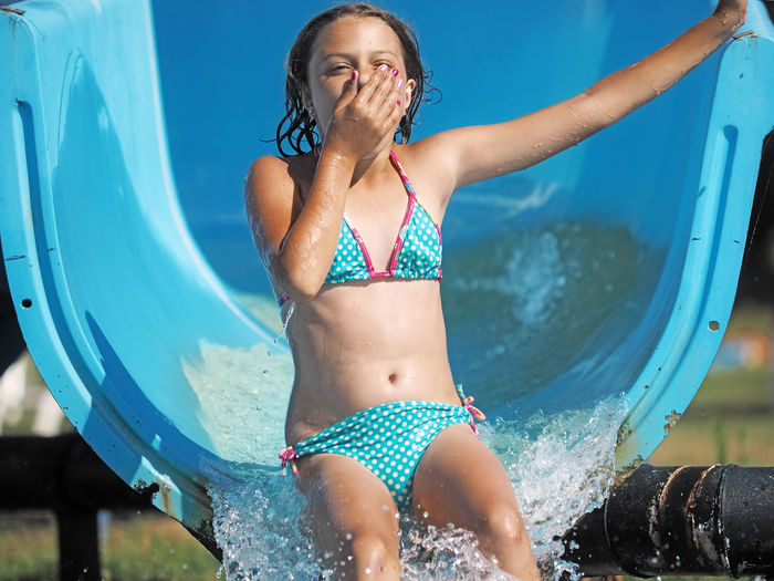 Girl enjoying water slide at park