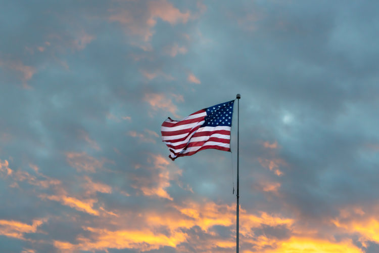 Low angle view of flag against sky during sunset