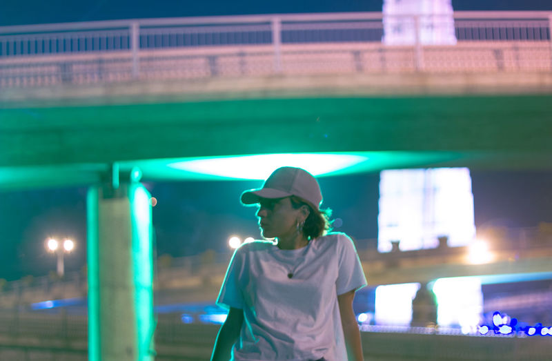 Woman looking at illuminated camera at night