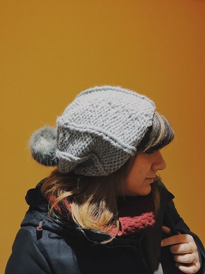 Close-up of woman against orange background