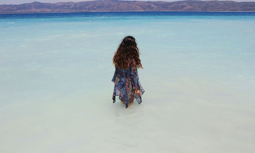 Rear view of woman standing in sea