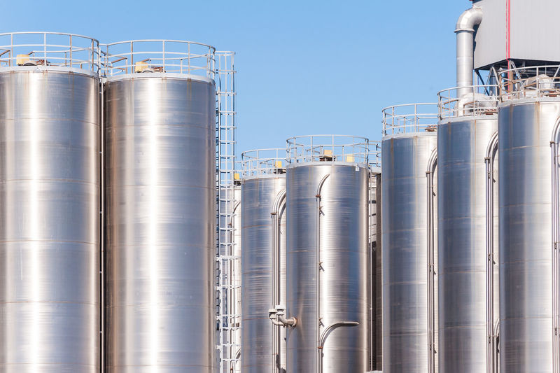 Silos in factory against sky