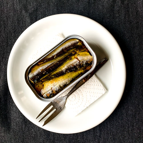 High angle view of sardines in can on plate
