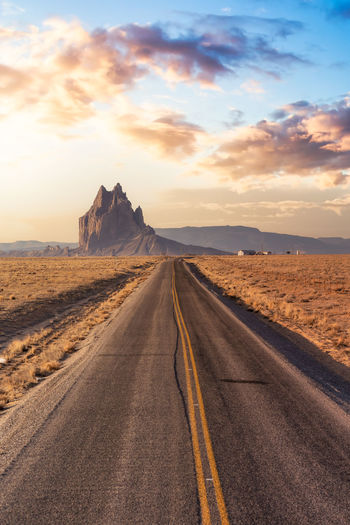 Road amidst desert against sky during sunset