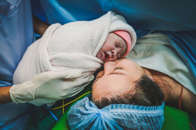 Mommy and baby newborn in the cesarean section. first sight of mom and her newborn in operation room
