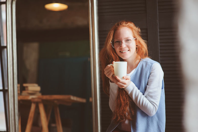 Portrait of smiling woman having coffee at home