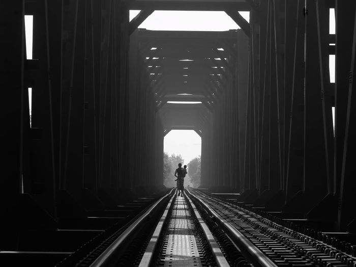 Rear view of man walking on railroad station