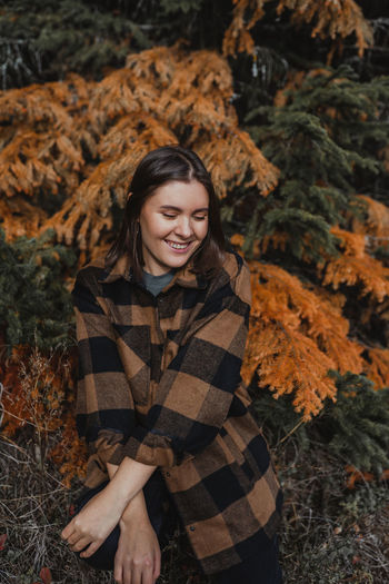Portrait of smiling young woman during autumn