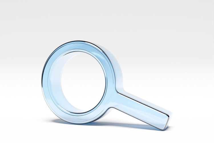 Close-up of magnifying glass against white background