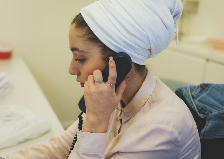 Woman wearing headscarf talking on telephone