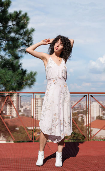 Portrait of woman standing on floor against sky