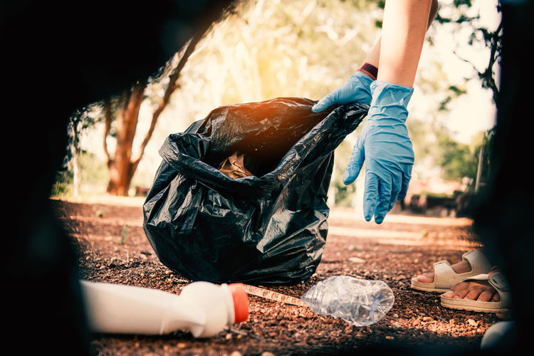 Volunteer holding plastic garbage clean to dispose of waste properly.