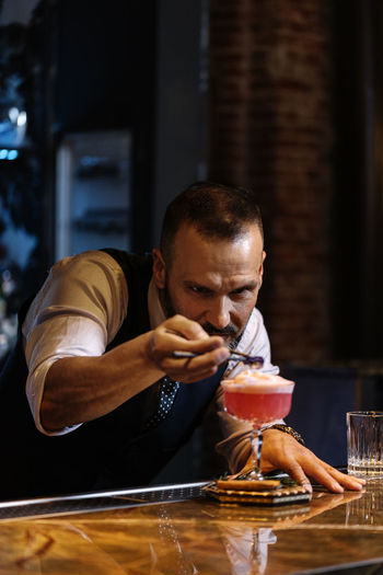 Concentrated bartender making drinks at counter