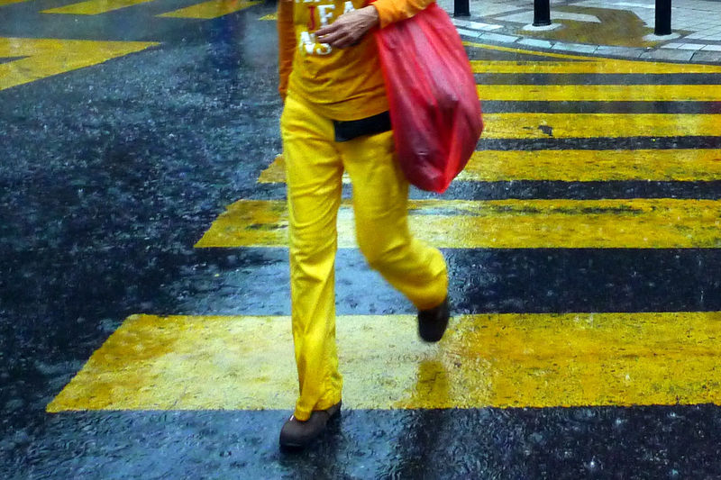 Low section of man walking on wet road