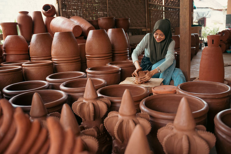 Female potter working in store