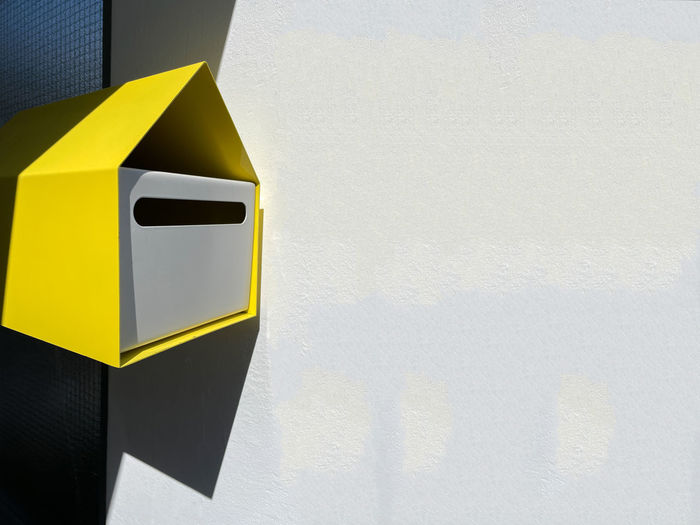 Yellow mail box on the white wall