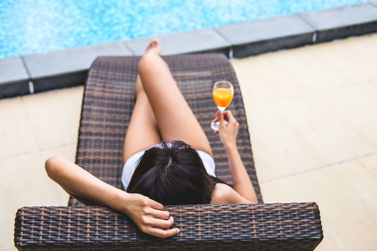 Woman having juice at poolside
