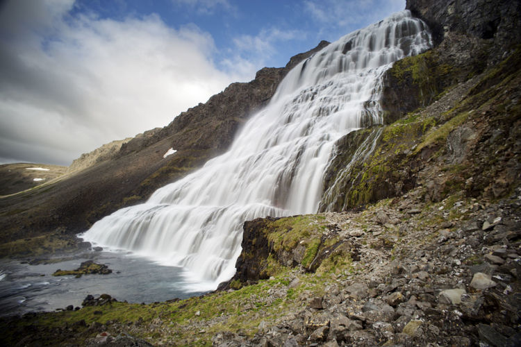 Scenic view of waterfall against sky