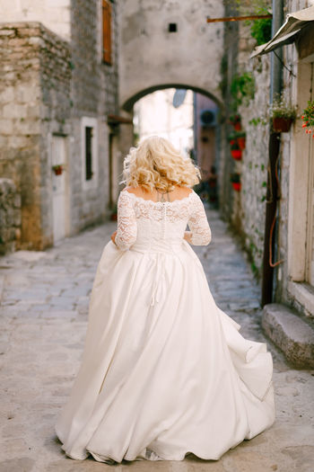 Rear view of bride standing in alley