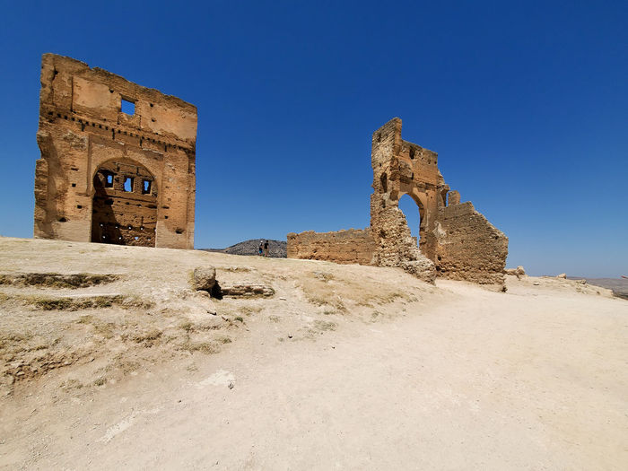 Low angle view of old ruin building against blue sky