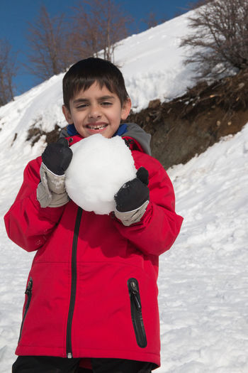 Portrait of happy boy with snowball