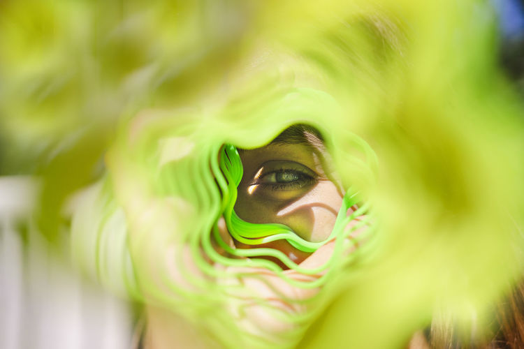 Woman looking through green metal coil toy