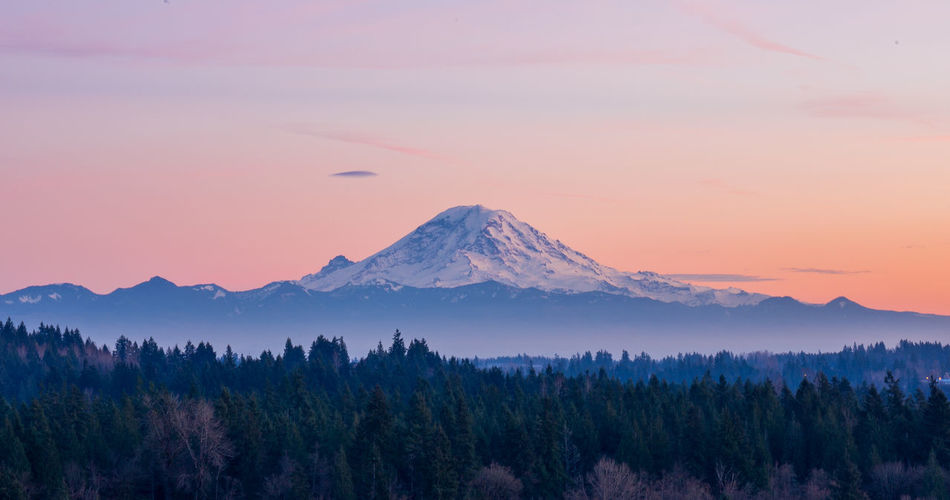 Scenic view of snowcapped mountains against sky at sunset