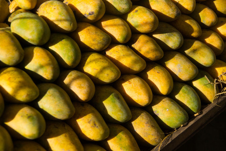 Mangoes stacked on a market stall