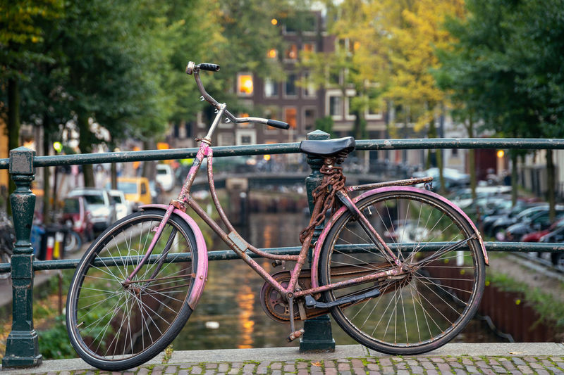 Bicycle parked by railing in canal