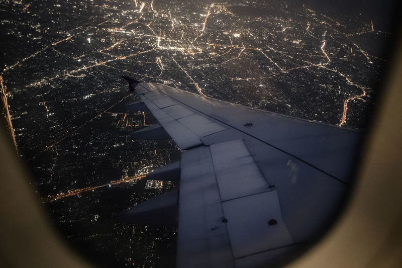Illuminated cityscape seen through airplane window