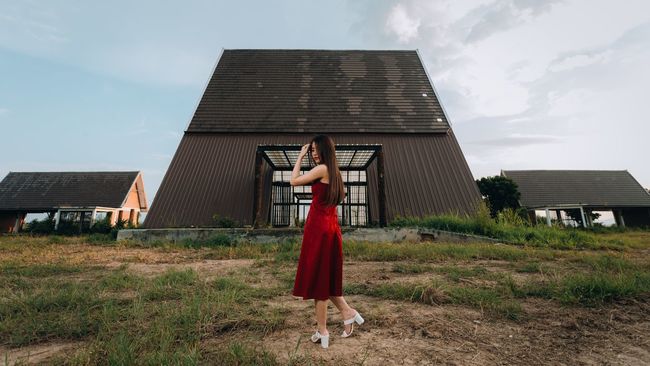 Woman walking on field against houses