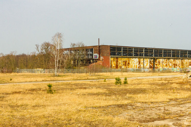 Abandoned building on field against clear sky