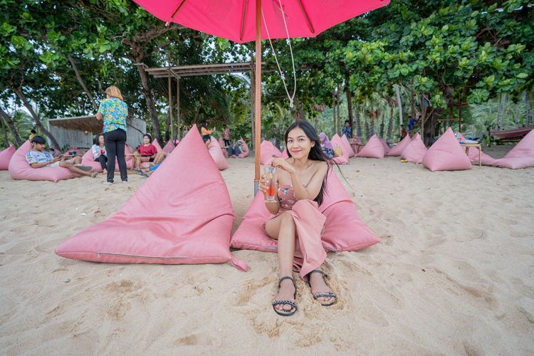 Portrait of woman sitting on sand at beach