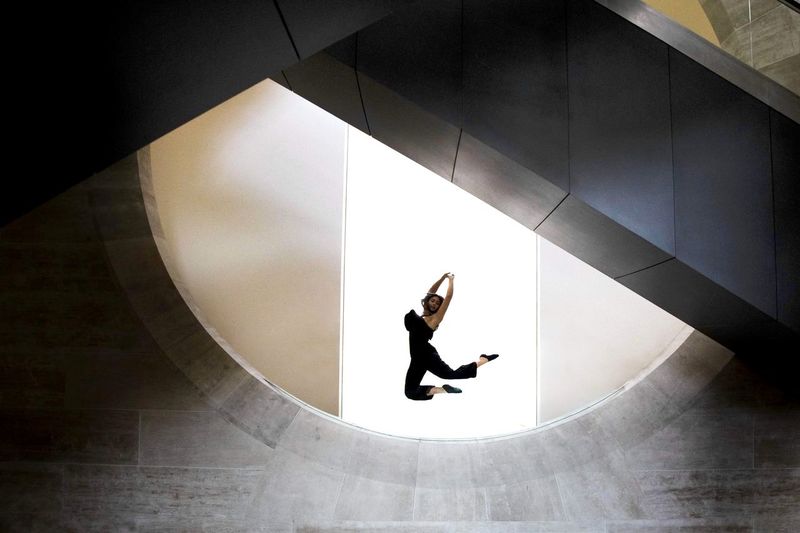 Low angle view of woman jumping against wall
