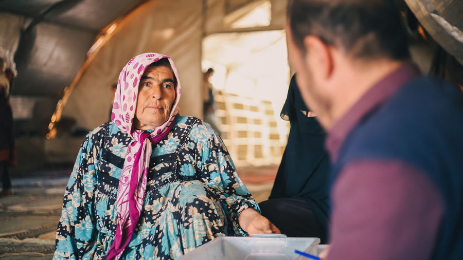 An elderly woman receives medical care at a makeshift medical clinic inside a syrian refugee camp.