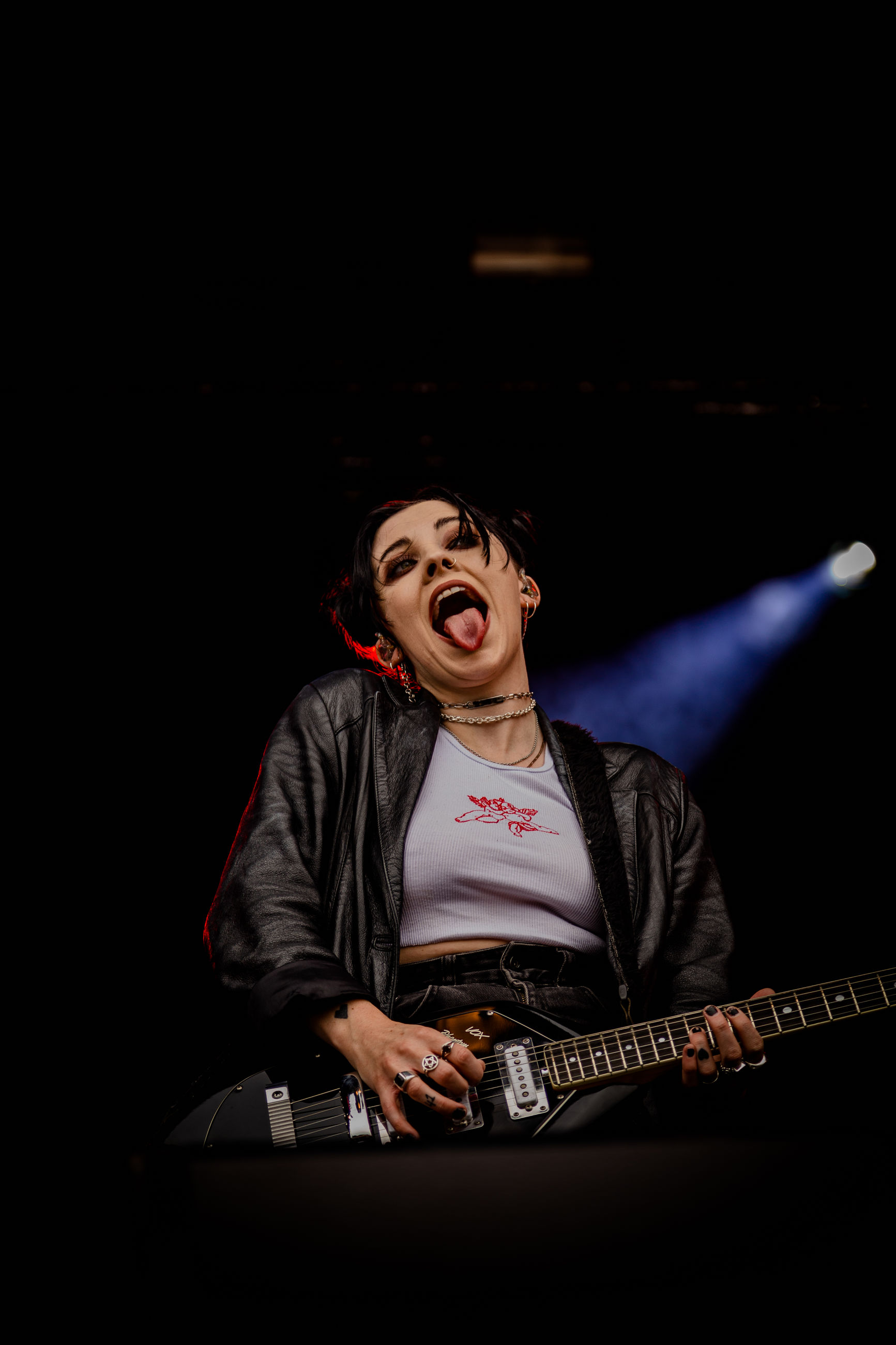 performance, mouth open, mouth, one person, music, front view, three quarter length, arts culture and entertainment, indoors, casual clothing, singing, young adult, young women, real people, leisure activity, musician, musical instrument, lifestyles, enjoyment, black background, stage, excitement, rock music, popular music concert