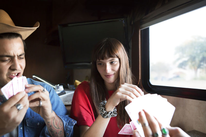 Couple playing cards while travelling in camper van