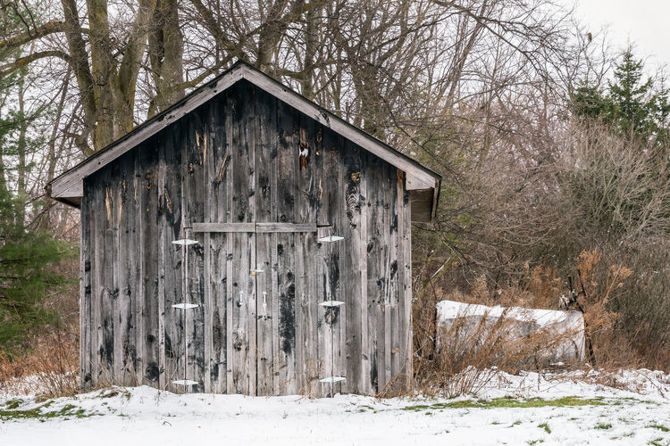 Abandoned cottage on snow covered field