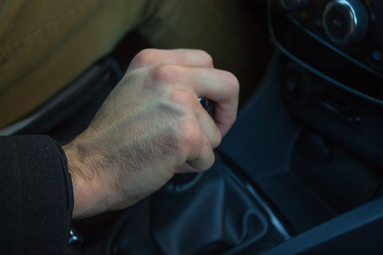 Man hand on gear lever in car