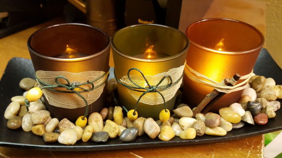 High angle view of candles with pebbles decoration in tray on table
