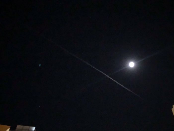 Low angle view of vapor trails in sky at night