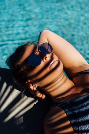 High angle view of woman wearing sunglasses at swimming pool