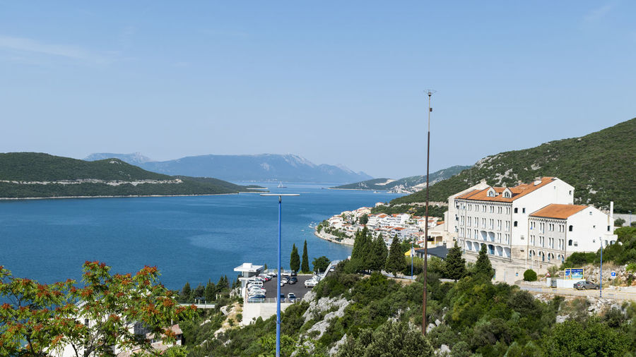 Buildings by sea against sky