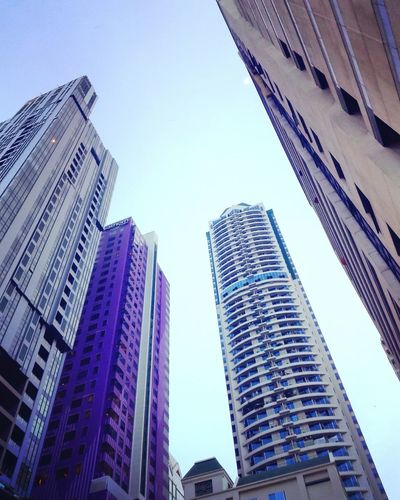 Low angle view of skyscrapers against blue sky