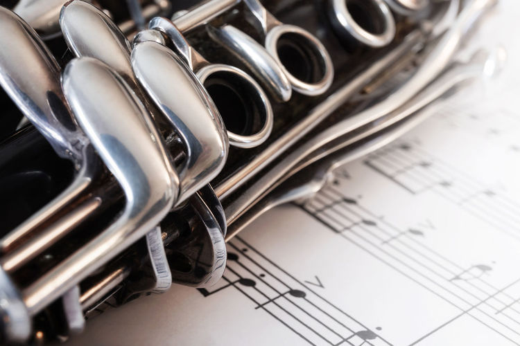 Close-up of clarinet on musical notes