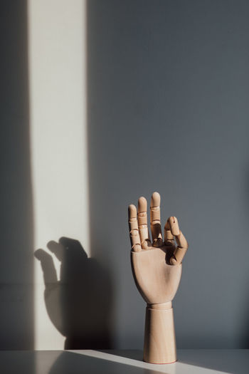 Close-up of hand on table against the wall