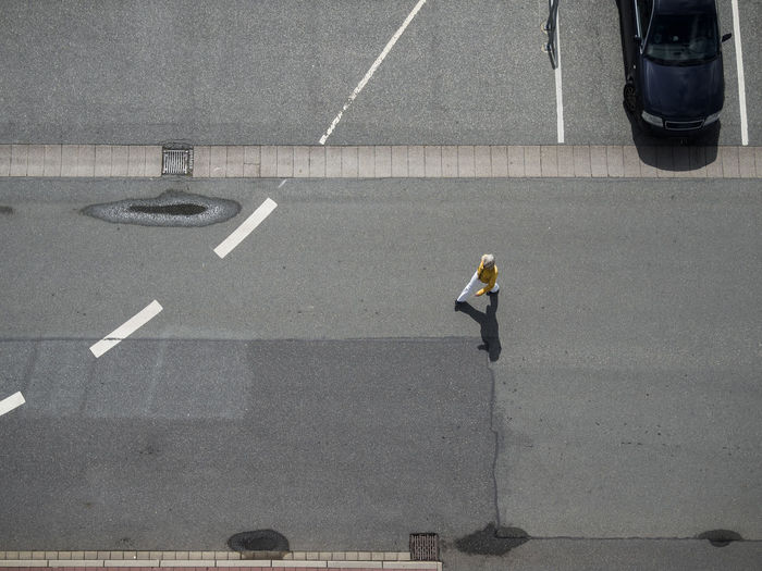 High angle view of man walking on road 