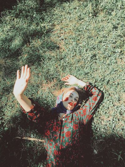 High angle portrait of woman with make-up lying on field