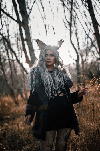 Young woman standing against tree during autumn