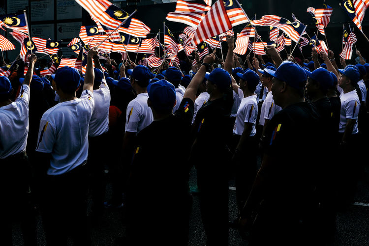People with malaysian flags in city during event
